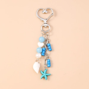 Detail showing heart clip with light blue beads, seashell and starfish charms on a keychain