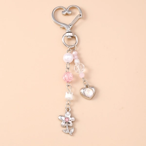 Détails de perles en cristal rose et de pendentifs en cœur sur un porte-clés argenté