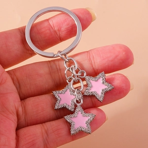 Sparkling pink star keychain with rhinestones and silver keyring held in hand