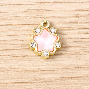 Detail of pink crystal star pendant with gold base and rhinestones for jewelry making