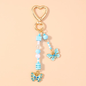 Dettaglio portachiavi farfalla con strass blu, perline e chiusura a cuore dorata