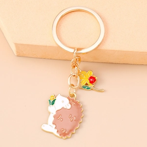 Detailed close-up of a golden hedgehog keychain with corn and small yellow flower charm