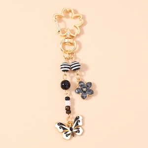 Detailed close-up of cherry blossom clasp and butterfly pendant keychain accessory