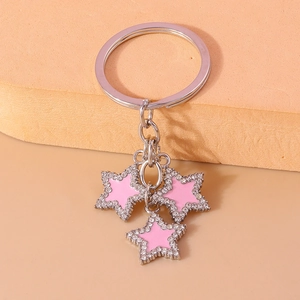 Close-up of pink crystal star pendants with shimmering rhinestone edges on a keychain