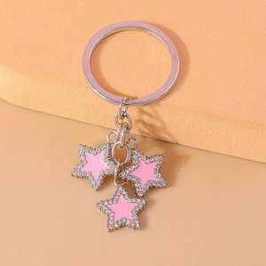 Detailed close-up of a silver star keychain featuring sparkling crystals and pink enamel