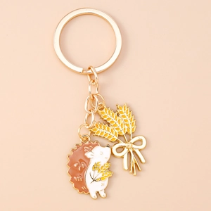 Macro shot of gold hedgehog and wheat pendants on an enamel keychain with fine detailing