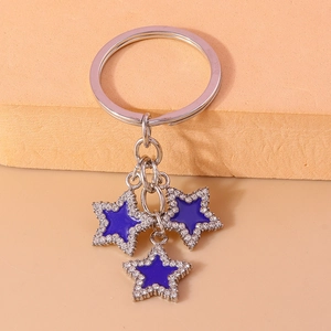 Close-up of luxury dark blue star pendants with white crystals and silver keychain ring