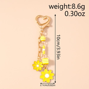 Detail of sunflower daisy keychain with heart-shaped clasp and yellow beaded flowers