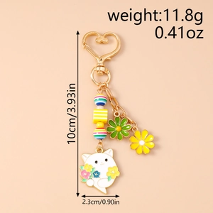 Detailansicht goldener Katzen-Schlüsselanhänger mit Emaille-Anhängern und Sonnenblumen