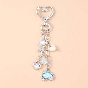 Dettaglio portachiavi a moschettone a cuore con nuvola glitter blu e ciondoli vari