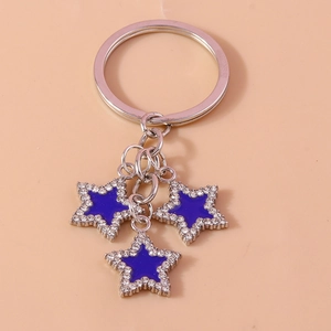Close-up of sparkling star keychain with blue enamel and rhinestones on silver metal