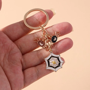 Detail of Halloween keychain with cute cartoon spiders and white spider web pendant