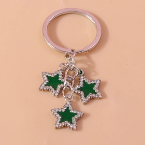 Detail of silver star keychain with green enamel centers and sparkling rhinestones