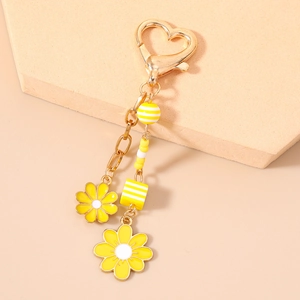 Fashionable daisy keychain with yellow beads and heart hook on a modern display pedestal