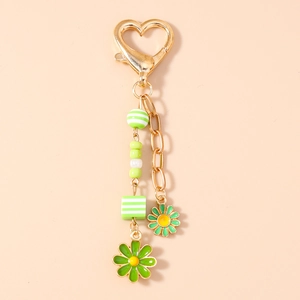 Close-up of a gold heart clasp with green striped beads and enamel daisy pendants