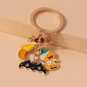 Detail of Halloween keychain with moon, bat and pumpkin charms on a golden metal ring