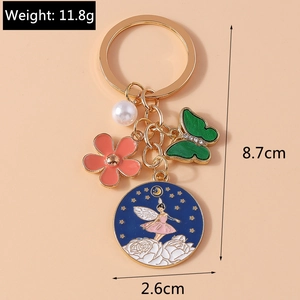 Détail du porte-clés fée avec fleur rose, perle et dimensions du charme émaillé bleu