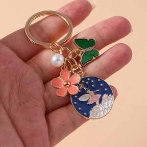 Porte-clés féerique avec fleur, papillon et pendentif émaillé bleu au style bohème