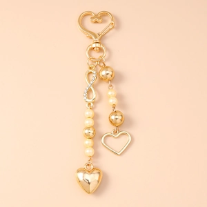 Detail of golden heart keychain with infinity symbol, pearls, and sparkling rhinestones