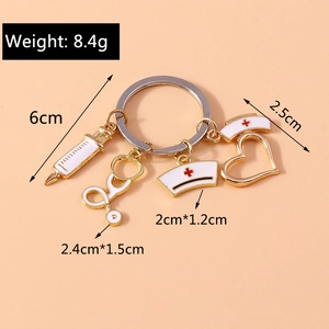 Detailed view of gold medical keychain with syringe and nurse hat charms on pink background