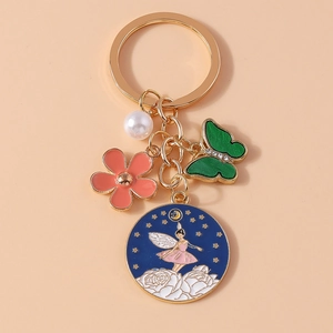 Détail du porte-clés fée avec pendentif rond en émail bleu et breloques de fleurs