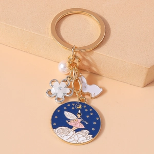 Porte-clés doré tendance avec breloque fleur, lapin émaillé, perle et pendentif fée bleue