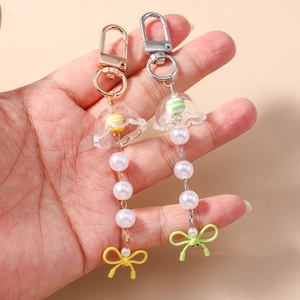 Porte-clés avec nœud en strass, fleur en coquillage et clochettes en perles
