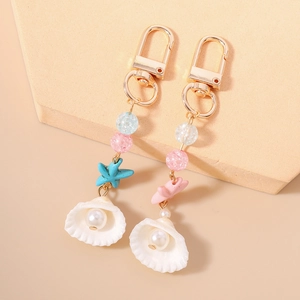 Ocean-themed beaded keychain set with golden starfish, pearls, and shells