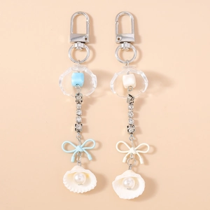 Vue détaillée de porte-clés style océan avec strass et coquillages sur fond rose