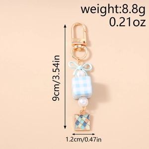 Macro shot of blue checkered cube keychain with ribbon bow and white pearl charms