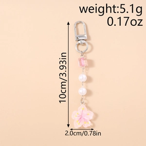 Detailed view of pink resin cherry blossom pendant with white pearls and silver clasp