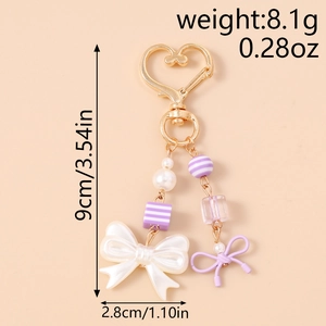 Detailed view of beaded keychain with pearls, purple bows, and heart clasp measurements