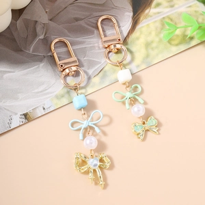Porte-clés élégant en perles avec nœuds et pendentifs cœurs sur mousquetons dorés raffinés