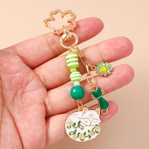 Details von Fuchs und Katze Emaille Anhängern an einem vergoldeten Kirschblüten Ring