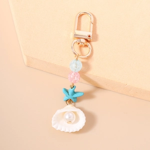 Detail view of ocean-themed keychain with starfish, seashell and faux pearl bead