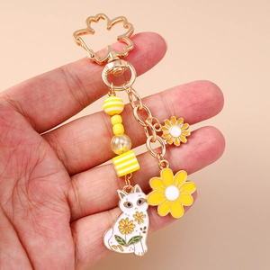Nahaufnahme vom goldenen Sakura-Haken mit niedlicher weißer Katze und gelben Blumen