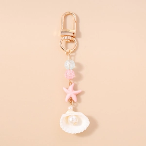 Detail showing ocean-themed keychain with sea star, white shell charm and imitation pearl