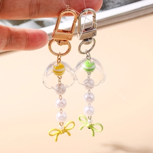 Porte-clés méduse créatifs avec perles colorées et rubans doux tenus à la main