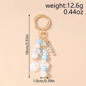 Détail du porte-clés perlé avec nœud bleu, pendentif coquille et dimensions de la chaîne