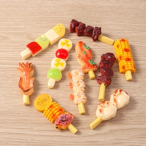 Macro shot of realistic resin fake food skewers with glossy finish on wood background
