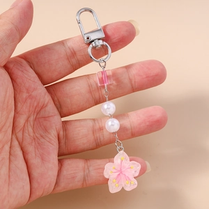 Detail of cherry blossom keychain with pink resin flower and transparent square bead