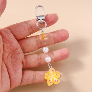 Detail of yellow translucent cherry blossom keychain with beads and silver lobster clasp