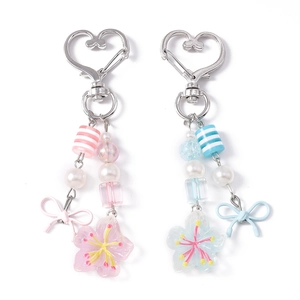 Portachiavi alla moda con fiori di ciliegio con perline a righe e fiocco nei colori rosa e blu