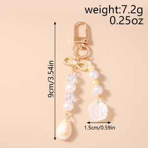 Detail showing beaded keychain with gold bow and shell pendant including dimensions