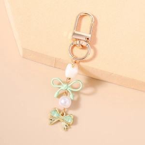 Détail du porte-clés perle élégant avec nœud vert menthe et breloque papillon scintillante