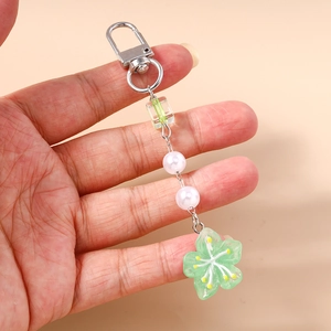 Detail of sweet beaded flower keychain with resin petal charm and imitation pearls