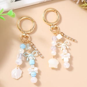 Porte-clés chic avec chaîne en strass, perles acryliques, nœud et coquillage de sac
