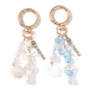 Porte-clés tendance avec strass, perles et nœud sur un fermoir doré élégant