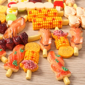 Macro detail of miniature resin grilled skewers and corn food models for DIY crafts