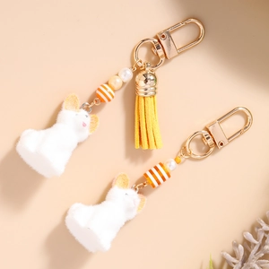 Porte-clés chien en peluche blanche avec pompon jaune et perles crochet doré